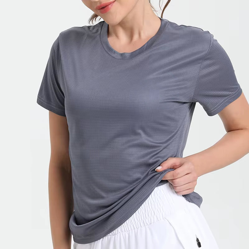 Solid gray ultralight quick-dry sport T-shirt for women, breathable performance fabric, worn with white shorts.